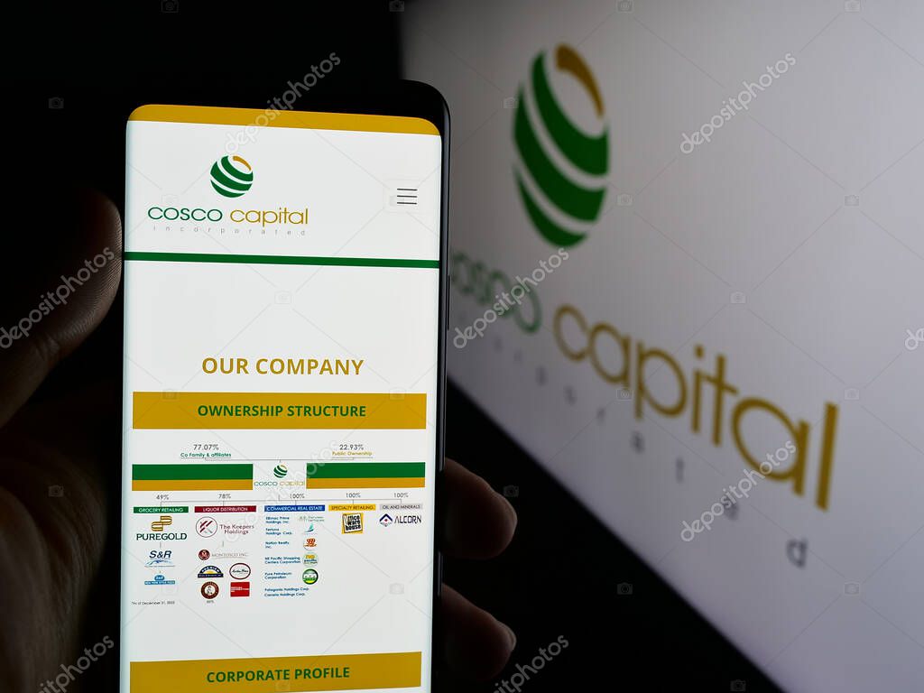Stuttgart, Germany - 06-04-2025: Person holding cellphone with webpage of investment company Cosco Capital Inc. on screen in front of logo. Focus on center of phone display.