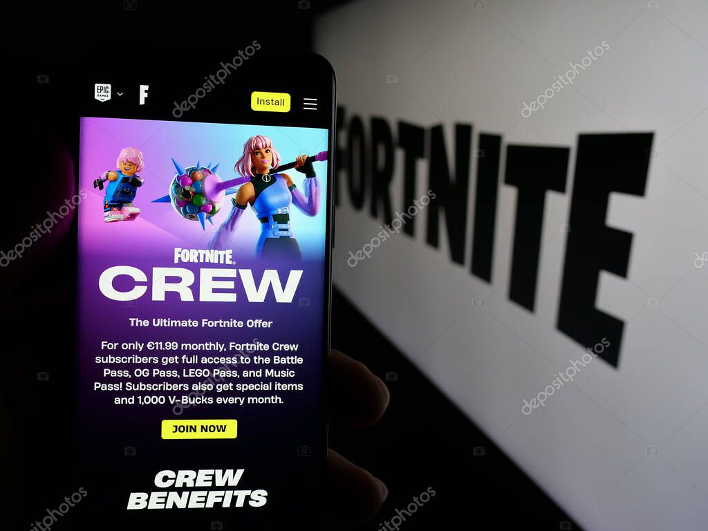 Stuttgart, Germany - 06-05-2025: Person holding cellphone with webpage of online video game platform Fortnite on screen in front of logo. Focus on center of phone display.