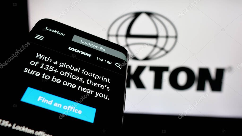 Stuttgart, Germany - 06-05-2025: Mobile phone with website of financial services company Lockton Companies on screen in front of logo. Focus on top-left of phone display.