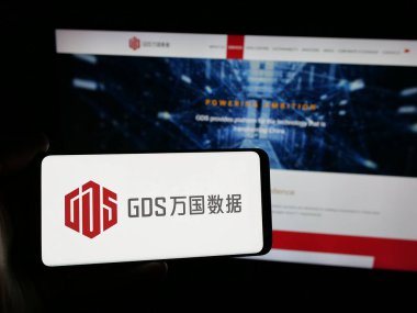Stuttgart, Almanya - 06-06-2025: Çinli veri merkezi şirketi GDS Holding Ltd. 'nin logosuna sahip kişi web sitesinin önünde ekranda. Telefon ekranına odaklan.