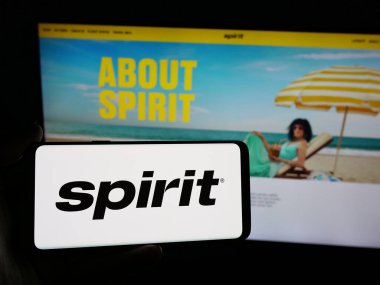 Stuttgart, Almanya - 06-06-2025: Web sitesinin önünde ekranda ABD 'li düşük maliyetli Spirit Airlines Inc. şirketinin logosunun bulunduğu akıllı telefonu tutan kişi. Telefon ekranına odaklan.