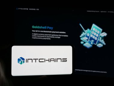 Stuttgart, Almanya - 06-07-2025: Şifreleme şirketi Intchain Group Limited 'in logosuna sahip akıllı telefon sahibi kişi web sitesi önünde ekranda. Telefon ekranına odaklan.