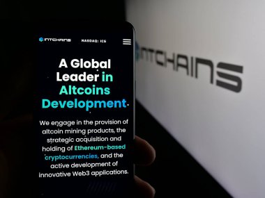Stuttgart, Almanya - 06-07-2025: Logonun önünde ekranda şifreli madencilik şirketi Intchain Group Limited 'in web sayfası bulunan akıllı telefon sahibi kişi. Telefon ekranının merkezine odaklan.