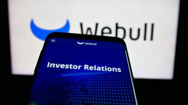 Stuttgart, Almanya - 06-07-2025: E-ticaret şirketi Webuy Global Ltd. 'nin web sitesiyle birlikte cep telefonu logonun önünde ekranda. Telefon ekranının sol üst kısmına odaklan.