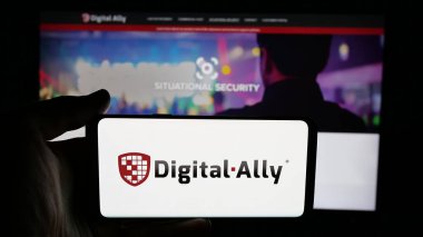 Stuttgart, Almanya - 06-07-2025: Web sayfasının önünde ekranda ABD 'li video çözümleme şirketi Digital Ally Inc.' in logosuna sahip cep telefonu bulunan kişi. Telefon ekranına odaklan.