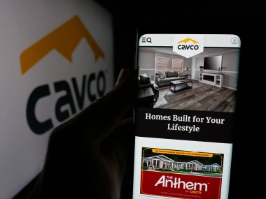 Stuttgart, Almanya - 06-07-2025: ABD 'li ev yapımı şirketi Cavco Industries Inc.' in web sayfası ile akıllı telefon sahibi kişi logonun önünde ekranda. Telefon ekranının merkezine odaklan.