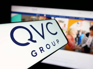 Stuttgart, Almanya - 06-07-2025: İnternet sitesi önünde ekranda QVC Group Inc. adlı ABD 'li medya şirketinin logosuna sahip akıllı telefon. Telefon ekranının merkez soluna odaklan.