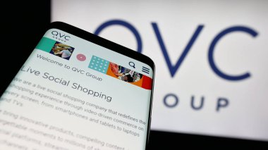 Stuttgart, Almanya - 06-07-2025: ABD 'li medya kuruluşu QVC Group Inc.' nin web sitesiyle birlikte cep telefonu logo önünde ekranda. Telefon ekranının sol üst kısmına odaklan.