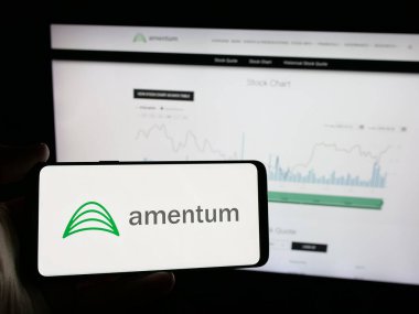 Stuttgart, Almanya - 06-07-2025: ABD 'li müteahhit firma Amentum Holding Inc.' nin logosunu elinde tutan kişi web sitesinin önünde ekranda. Telefon ekranına odaklan.