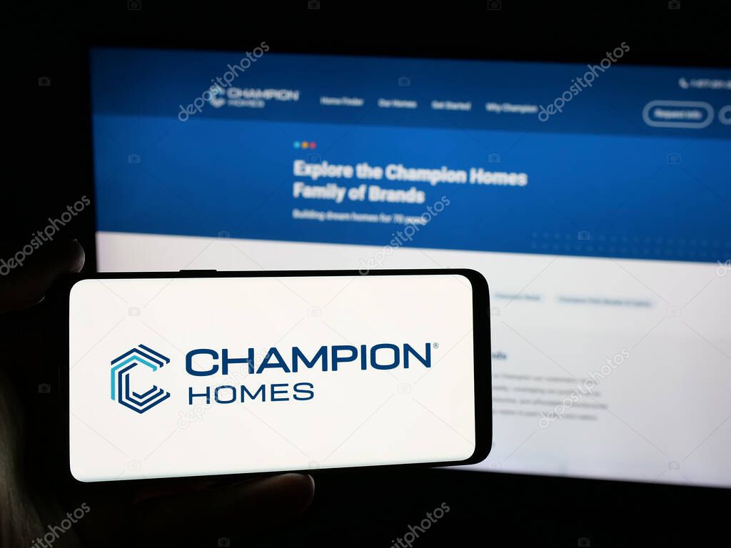 Stuttgart, Germany - 06-06-2025: Person holding smartphone with logo of US homebuilding company Champion Homes Inc. on screen in front of website. Focus on phone display.