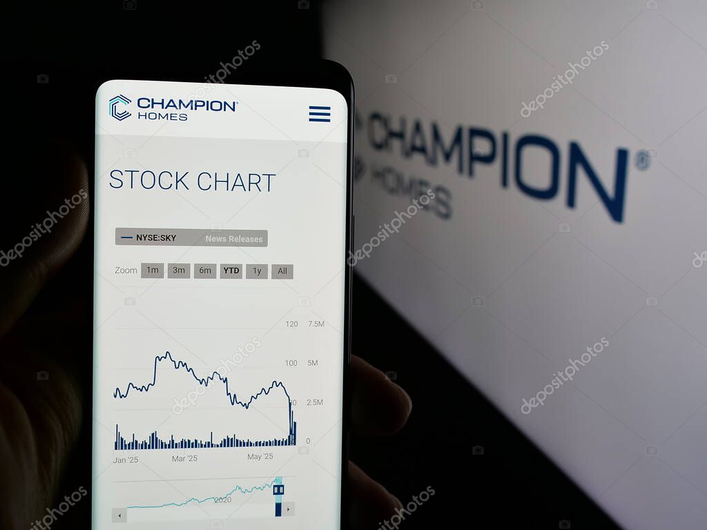 Stuttgart, Germany - 06-06-2025: Person holding cellphone with webpage of US homebuilding company Champion Homes Inc. on screen in front of logo. Focus on center of phone display.