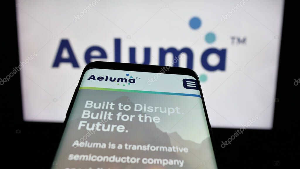 Stuttgart, Germany - 06-07-2025: Mobile phone with website of US semiconductor company Aeluma Inc. on screen in front of logo. Focus on top-left of phone display.