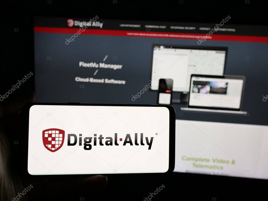 Stuttgart, Germany - 06-07-2025: Person holding smartphone with logo of US video solutions company Digital Ally Inc. on screen in front of website. Focus on phone display.