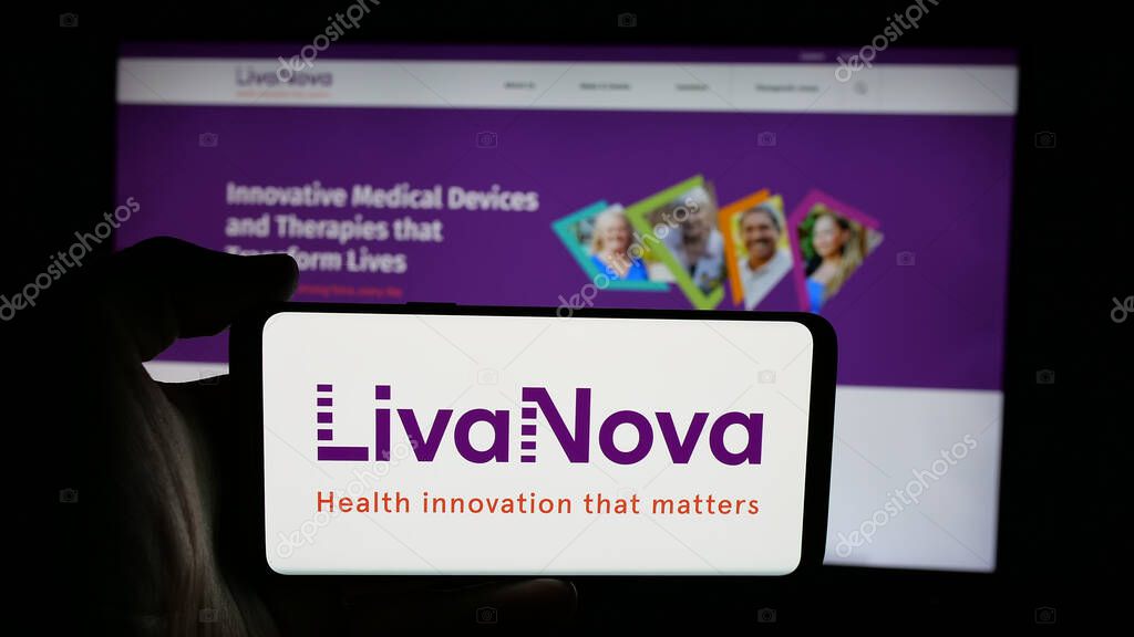 Stuttgart, Germany - 06-07-2025: Person holding cellphone with logo of medical device company LivaNova plc on screen in front of webpage. Focus on phone display.