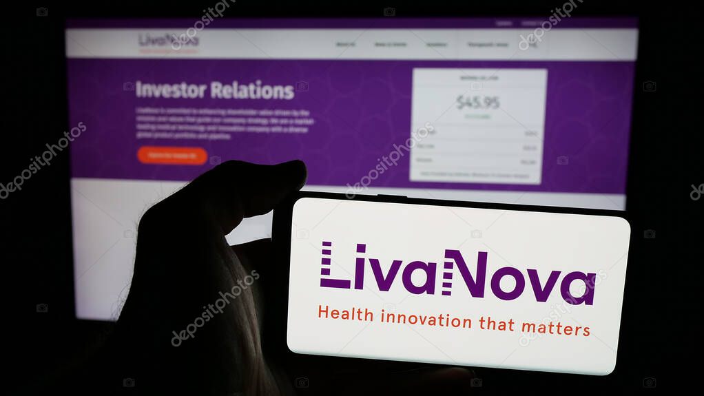 Stuttgart, Germany - 06-07-2025: Person holding mobile phone with logo of medical device company LivaNova plc on screen in front of web page. Focus on phone display.