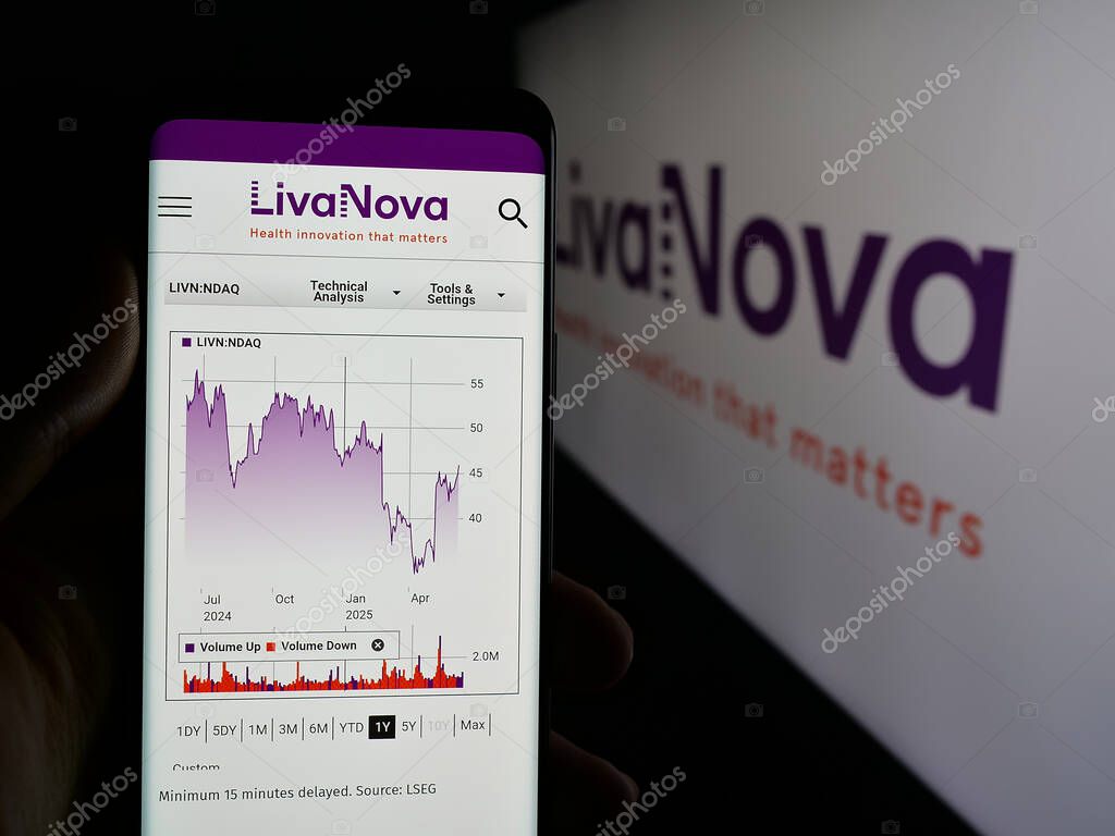 Stuttgart, Germany - 06-07-2025: Person holding smartphone with web page of medical device company LivaNova plc on screen in front of logo. Focus on center of phone display.