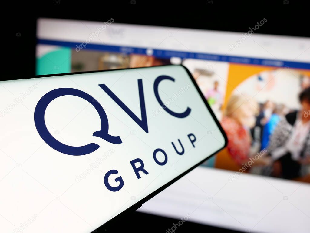 Stuttgart, Germany - 06-07-2025: Smartphone with logo of US media company QVC Group Inc. on screen in front of website. Focus on center-left of phone display.
