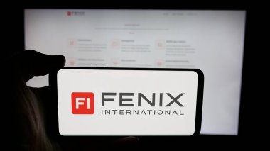 Stuttgart, Almanya - 06-08-2025: İnternet sayfası önünde Fenix International Limited (OnlyFans) logosu olan cep telefonu sahibi kişi. Telefon ekranına odaklan.