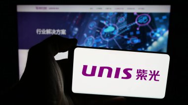 Stuttgart, Almanya - 06-08-2025: Web sayfasının önündeki ekranda Unisplendour Corporation Limited (UNIS) logosu olan cep telefonu sahibi kişi. Telefon ekranına odaklan.