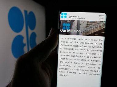 Stuttgart, Almanya - 06-08-2025: Logo önünde ekranda OPEC adlı petrol ihracat organizasyonunun web sayfası ile akıllı telefon tutan kişi. Telefon ekranının merkezine odaklan.