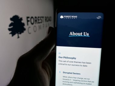 Stuttgart, Almanya - 06-08-2025: Yatırım şirketi Forest Road Company LLLC 'nin web sayfası logonun önünde duran kişi. Telefon ekranının merkezine odaklan.
