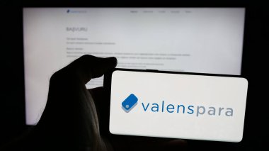 Stuttgart, Almanya - 06-08-2025: Türk şirketi ValensPara Odeme Kurulusu 'nun logosunu taşıyan cep telefonu sahibi kişi web sitesinin önünde ekranda görülüyor. Telefon ekranına odaklan.