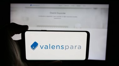 Stuttgart, Almanya - 06-08-2025: Türk şirketi ValensPara Odeme Kurulusu 'nun logosuyla cep telefonu tutan kişi web sitesinin önünde ekranda. Telefon ekranına odaklan.