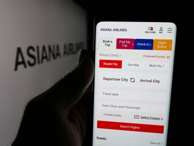 Stuttgart, Almanya - 06-09-2025: Koreli havayolu şirketi Asiana Airlines Inc. 'in web sayfası ile akıllı telefon sahibi kişi logonun önünde ekranda. Telefon ekranının merkezine odaklan.
