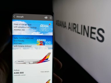 Stuttgart, Almanya - 06-09-2025: Koreli havayolu şirketi Asiana Airlines Inc. 'in web sayfası ile logo önünde cep telefonu tutan kişi. Telefon ekranının merkezine odaklan.