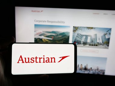 Stuttgart, Almanya - 06-09-2025: İnternet sitesi önünde üzerinde Avusturya Havayolları AG (AUA) logosu bulunan akıllı telefon sahibi kişi. Telefon ekranına odaklan.