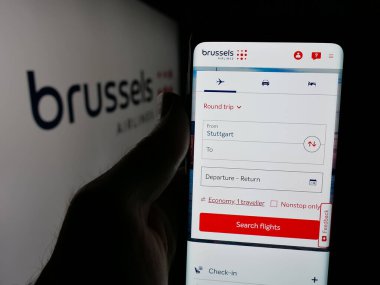 Stuttgart, Almanya - 06-09-2025: Belçikalı firma Brüksel Airlines 'ın internet sayfası ile akıllı telefonu olan kişi logonun önünde ekranda. Telefon ekranının merkezine odaklan.