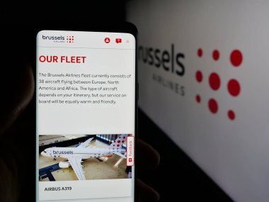 Stuttgart, Almanya - 06-09-2025: Belçikalı firma Brüksel Airlines 'ın internet sayfası ile cep telefonu tutan kişi logonun önünde ekranda. Telefon ekranının merkezine odaklan.