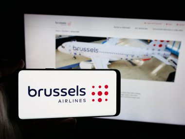 Stuttgart, Almanya - 06-09-2025: Belçikalı Brüksel Havayolları 'nın logosunun bulunduğu akıllı telefon sahibi kişi web sitesinin önünde ekranda. Telefon ekranına odaklan.