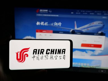 Stuttgart, Almanya - 06-09-2025: Çinli havayolu şirketi Air China Limited 'in logosuna sahip akıllı telefon sahibi kişi web sitesinin önünde ekranda. Telefon ekranına odaklan.
