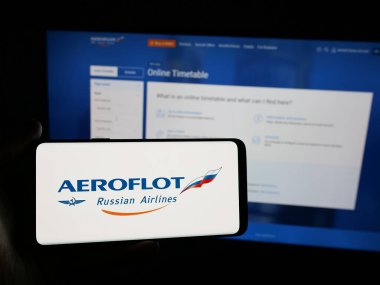 Stuttgart, Almanya - 06-09-2025: PJSC Aeroflot şirketinin logosunu taşıyan kişi - Rus Havayolları web sitesinin önünde ekranda. Telefon ekranına odaklan.