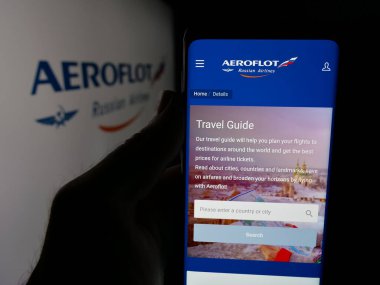 Stuttgart, Almanya - 06-09-2025: PJSC Aeroflot şirketinin web sayfası ile akıllı telefon taşıyan kişi - Rus Havayolları logonun önünde ekranda. Telefon ekranının merkezine odaklan.