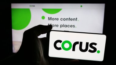 Stuttgart, Almanya - 06-09-2025: İnternet sayfası önünde üzerinde medya şirketi Corus Entertainment Inc. 'in logosu bulunan cep telefonu sahibi kişi. Telefon ekranına odaklan.