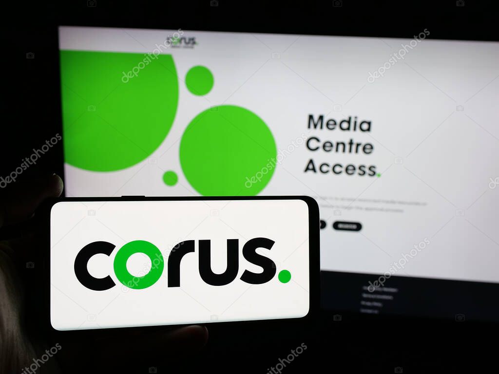 Stuttgart, Germany - 06-09-2025: Person holding smartphone with logo of media company Corus Entertainment Inc. on screen in front of website. Focus on phone display.