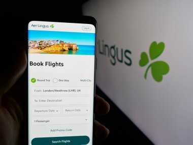 Stuttgart, Almanya - 06-11-2025: İrlandalı havayolu şirketi Aer Lingus 'un internet sayfası ile akıllı telefon taşıyan kişi logonun önünde ekranda. Telefon ekranının merkezine odaklan.