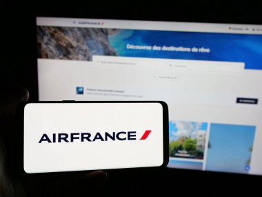 Stuttgart, Almanya - 06-11-2025: İnternet sitesinin önünde, üzerinde Societe Air France S.A. havayolu şirketinin logosu bulunan akıllı telefon sahibi kişi. Telefon ekranına odaklan.