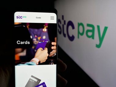 Stuttgart, Almanya - 06-13-2025: Cep telefonunda Suudi Arabistan dijital güvenli cüzdan STC Pay 'in web sayfası bulunan kişi logonun önünde ekranda. Telefon ekranının merkezine odaklan.