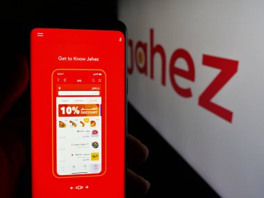 Stuttgart, Almanya - 06-13-2025: Suudi Arabistan gıda dağıtım uygulaması şirketi Jahez 'in web sayfası ile akıllı telefon taşıyan kişi logonun önünde ekranda. Telefon ekranının merkezine odaklan.