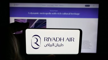Stuttgart, Almanya - 06-13-2025: Suudi Arabistan havayolu şirketi Riyad Air 'in logosunun bulunduğu cep telefonu web sayfası önünde ekranda. Telefon ekranına odaklan.