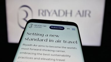 Stuttgart, Almanya - 06-13-2025: Suudi Arabistan havayolu şirketi Riyad Air 'in web sitesiyle birlikte logo önünde cep telefonu. Telefon ekranının sol üst kısmına odaklan.