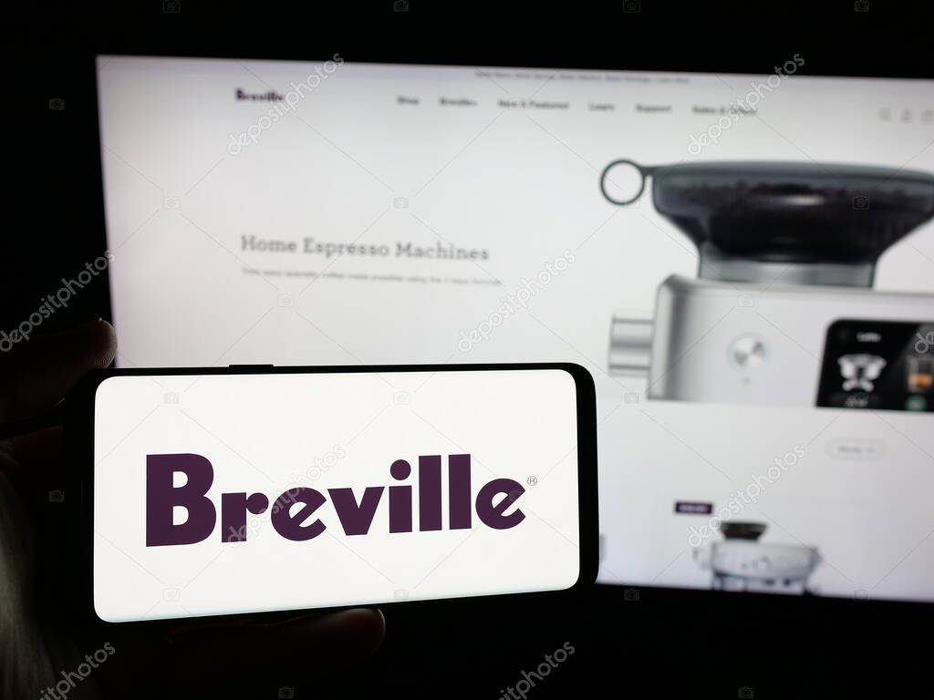 Stuttgart, Germany - 06-12-2025: Person holding smartphone with logo of home appliances company Breville Group Ltd. on screen in front of website. Focus on phone display.