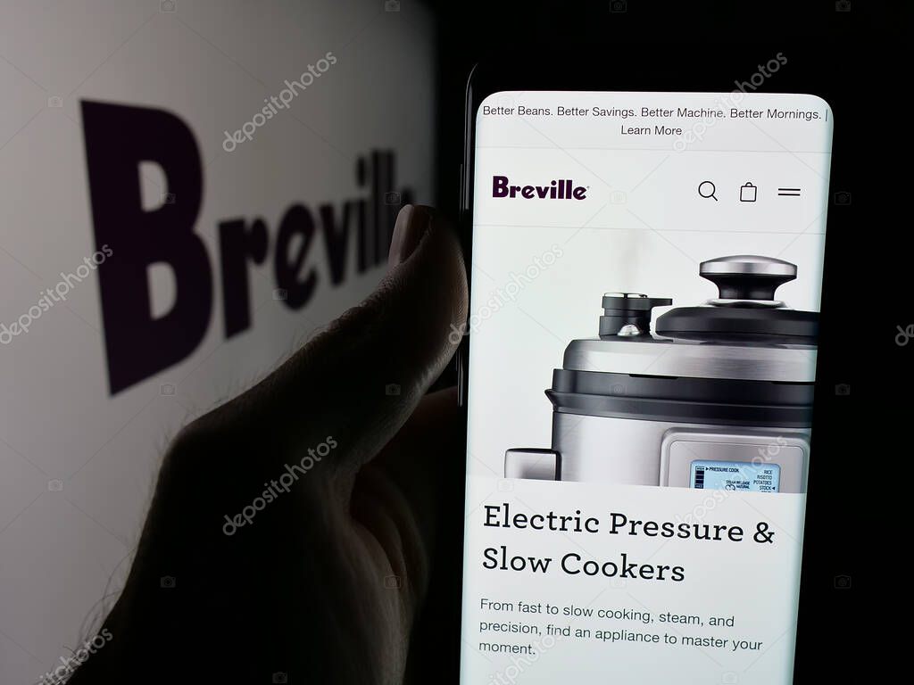 Stuttgart, Germany - 06-12-2025: Person holding smartphone with web page of home appliances company Breville Group Ltd. on screen in front of logo. Focus on center of phone display.