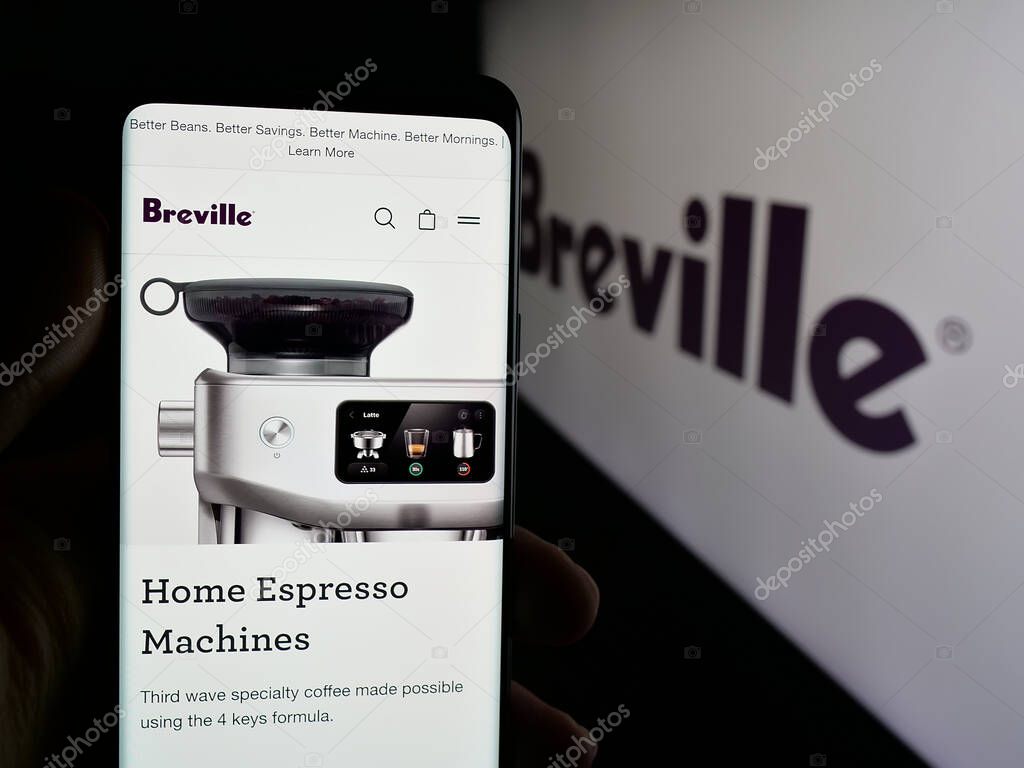 Stuttgart, Germany - 06-12-2025: Person holding cellphone with webpage of home appliances company Breville Group Ltd. on screen in front of logo. Focus on center of phone display.