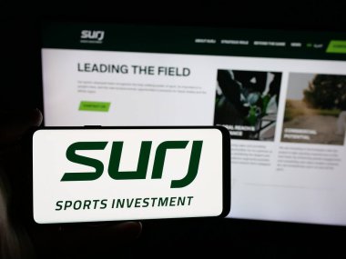 Stuttgart, Almanya - 06-14-2025: SURJ Sports Investment Company 'nin logosunun bulunduğu akıllı telefon web sitesi önünde ekranda. Telefon ekranına odaklan.
