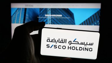Stuttgart, Almanya - 06-14-2025: İnternet sayfasının önünde Sürdürülen Altyapı Holding Co. (SISCO) logosu olan cep telefonu sahibi kişi. Telefon ekranına odaklan.