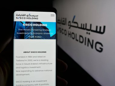 Stuttgart, Almanya - 06-14-2025: Logonun önündeki ekranda Sürdürülebilir Altyapı Holding Co. (SISCO) web sayfası olan akıllı telefon sahibi kişi. Telefon ekranının merkezine odaklan.